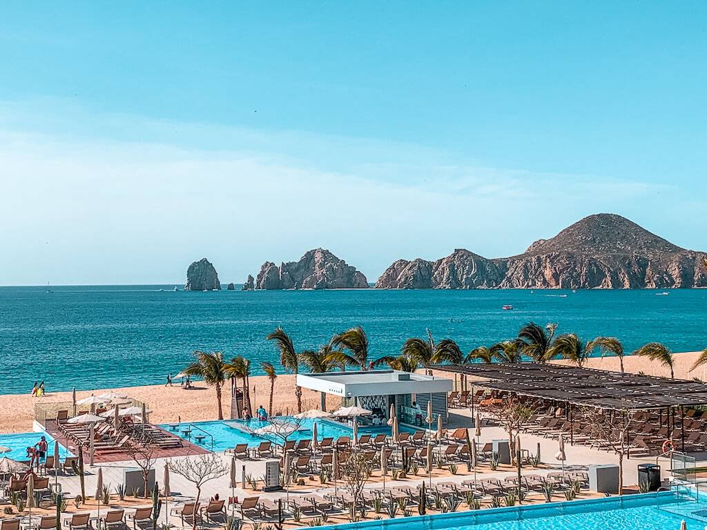 looking over the pool area at Riu Palace Baja California all-inclusive resort in Mexico, with the Los Arcos rock formations in the distance