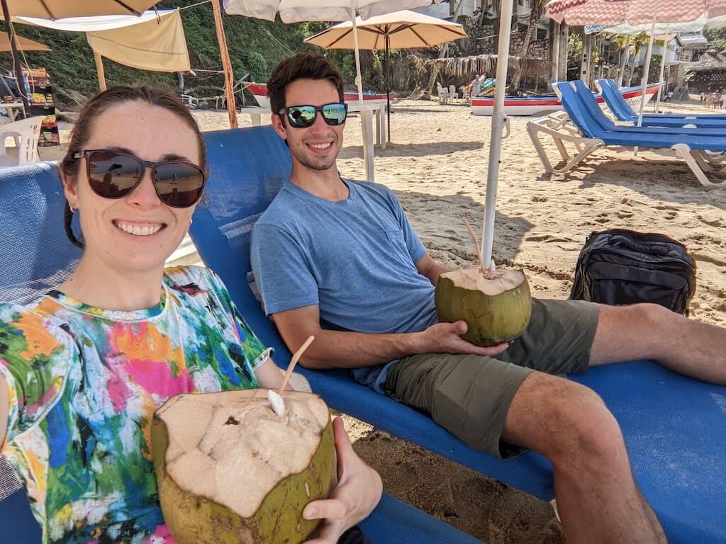 Evan and Jen drink from Cocos Frios while sitting on sun loungers after hiking to Las Animas from Boca de Tomatlan