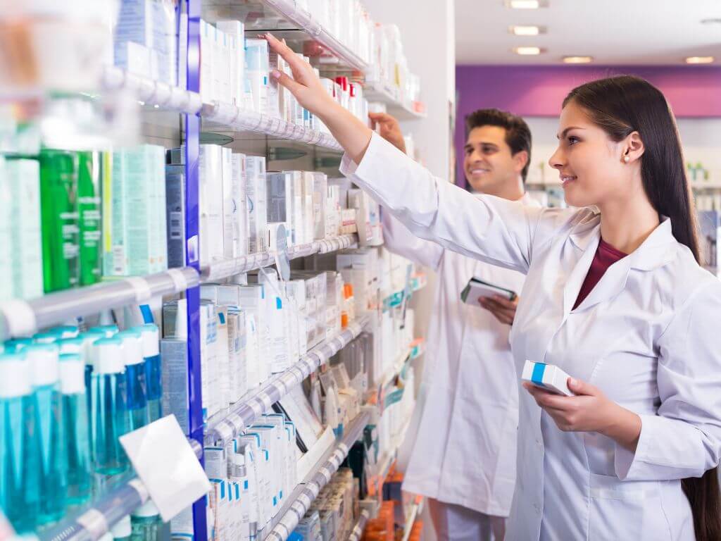 A pharmacist reaches for medication on a high shelf, preparing to prevent altitude sickness in the elevated city of Mexico City.