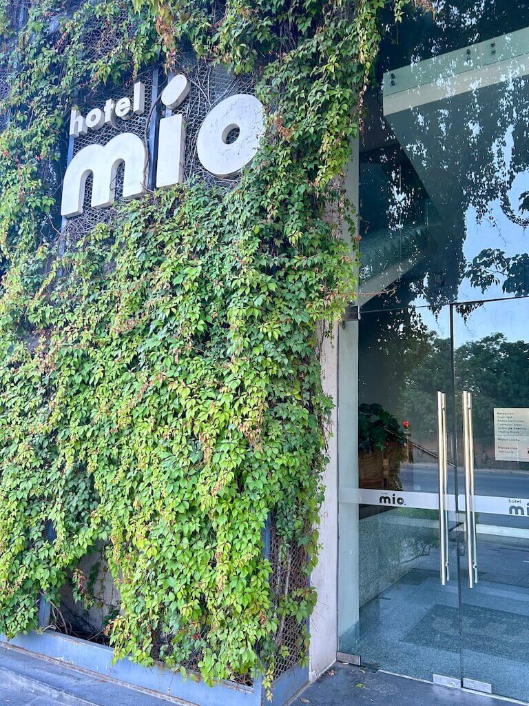 glass doors at the front of hotel mio vallarta, with green vines coverting the exterior wall