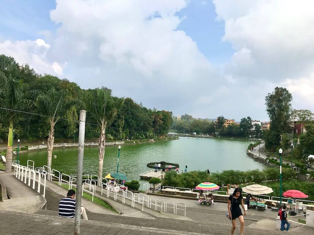 looking out over los lagos park, the jogging path wraps around the edge of the lake and the green lake sits in the center