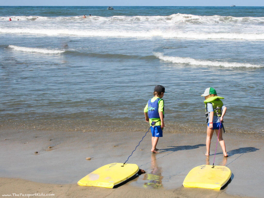 Two kids getting ready to go boogie boarding in Sayulita, Mexico