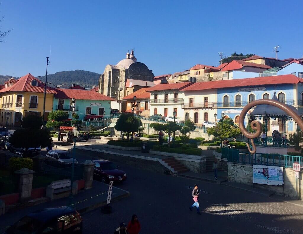 downtown mineral de monte with colorful buildings in the background and shady street in the foreground