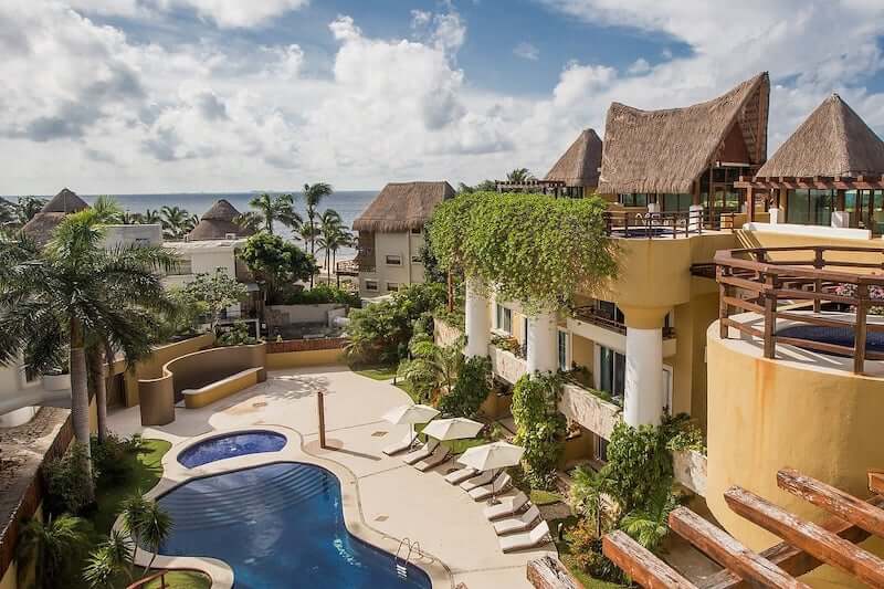 looking down at the communal pool area from the balcony of a playa del carmen condo airbnb