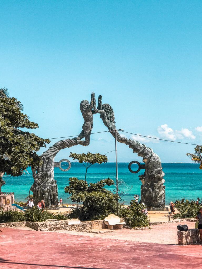 looking across the empty Parque Fundadores plaza to the famous Playa del Carmen mermaid arches with the turquoise Caribbean Sea in the background