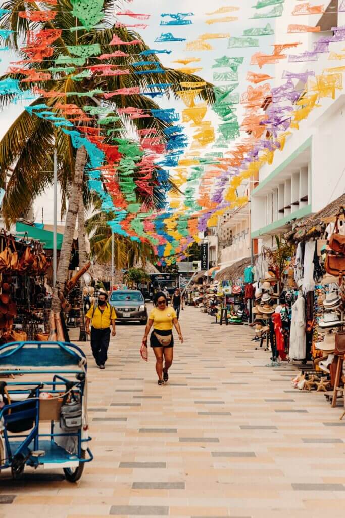 woman walks down La Quinta Avenida in Playa del Carmen, Mexico, one of Mexico's most popular solo travel destinations.