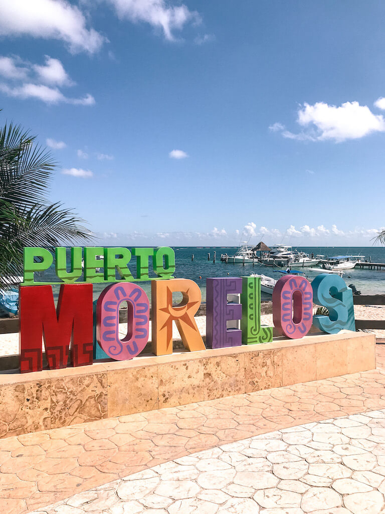 Colorful Puerto Morelos sign with ocean in the background