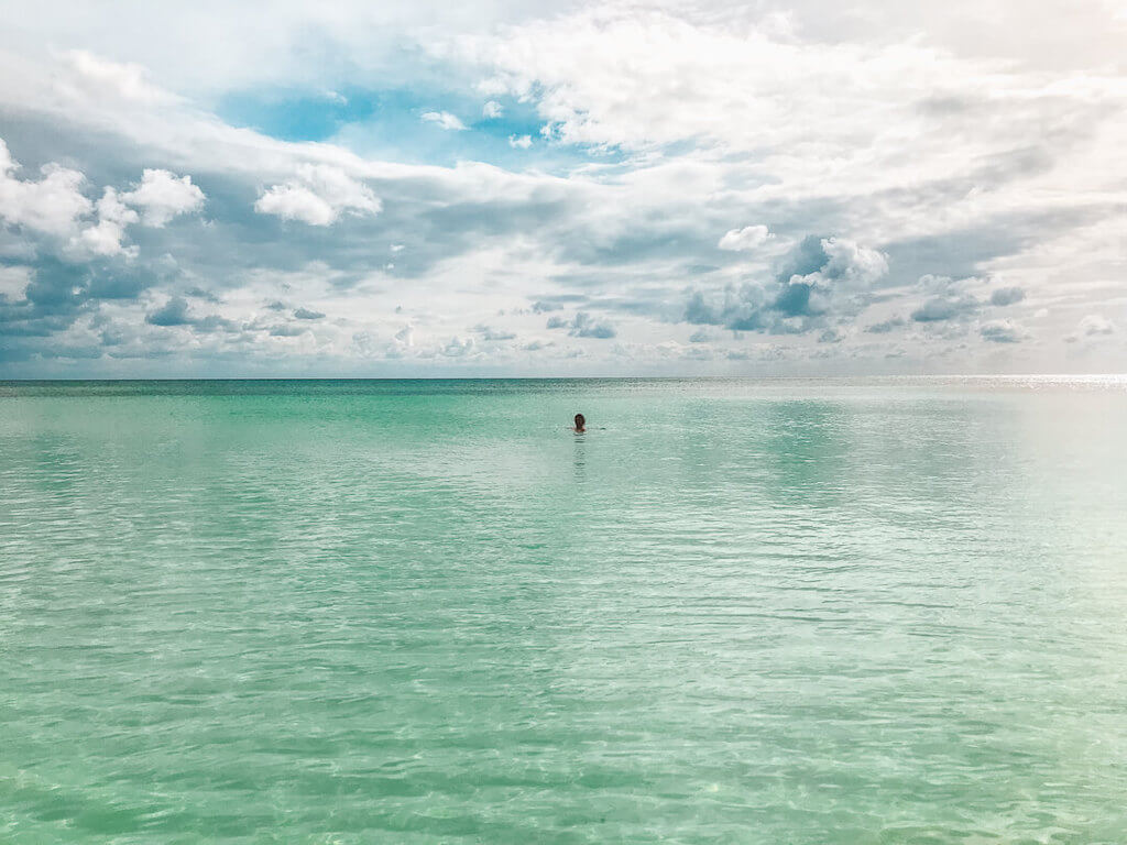 A distant shot of Janine swimming all alone in the glassy water at El Cielo Beach on Cozumel Island