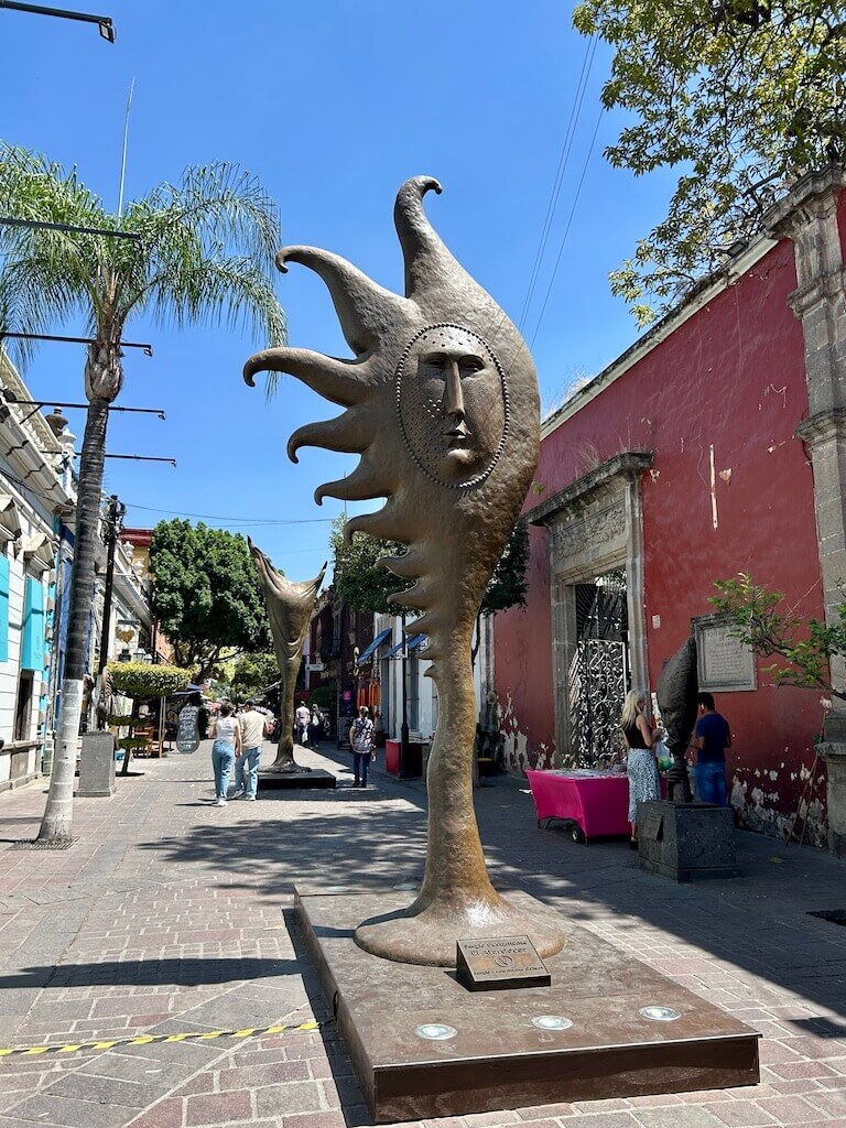 sun sculpture with a face in the middle of a colorful pedestrian street in Tlaquepaque, Guadalajara