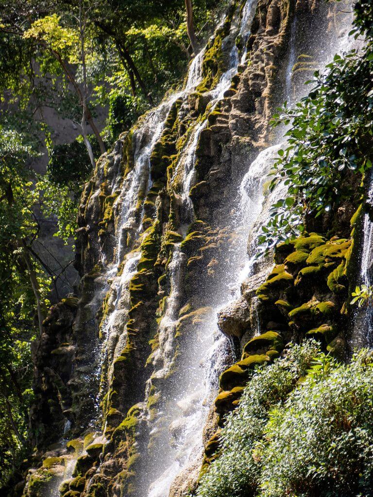 water cascades down over mossy green rocks at Las Grutas de Tolantongo, Mexico